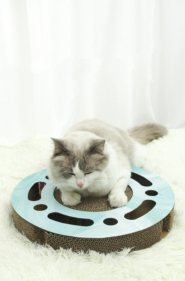 Cat relaxing and playing on the PawPuzzle™ round interactive scratching board.
